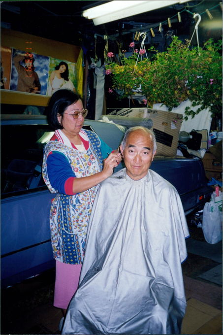 Jeanne cutting Carl's hair in the garage
